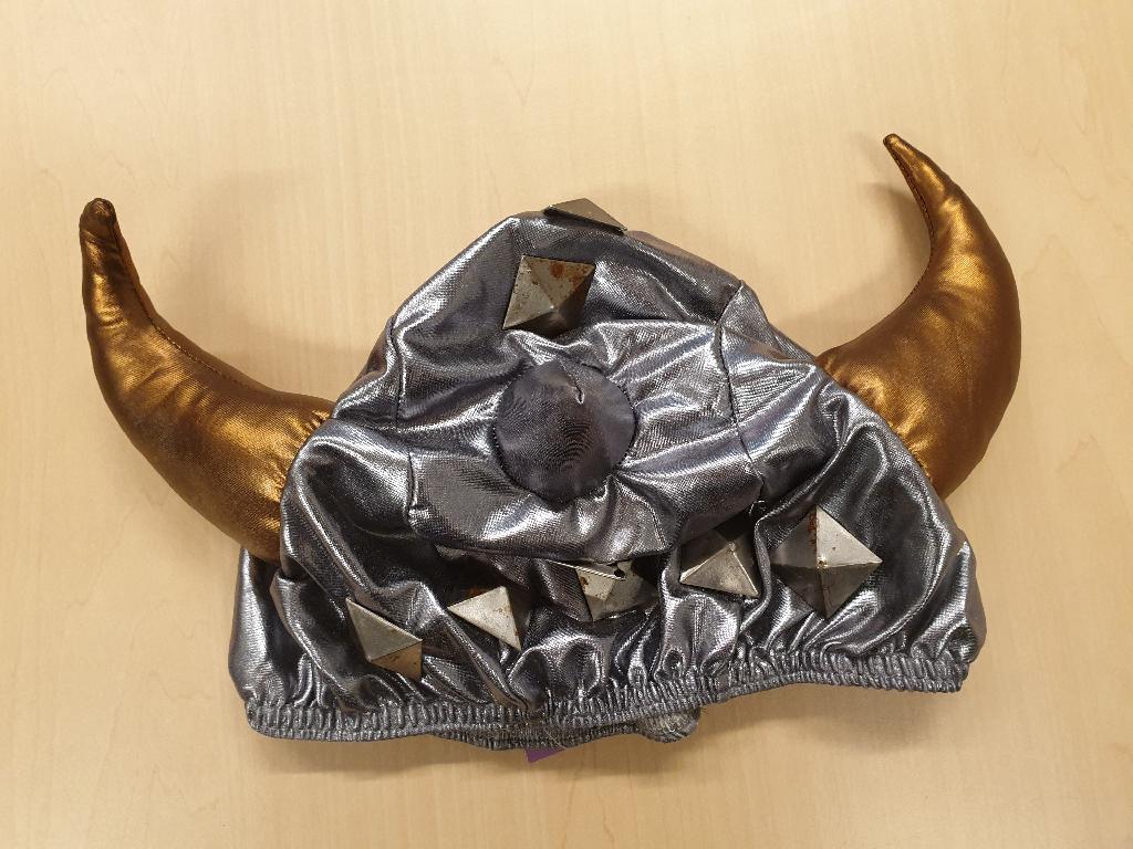 Een zogenaamde strecheehead, zijnde een overtrek voor een hoofddeksel met -volgens opgave- onder meer de volgende kenmerken:
- bestemd om over een helm bevestigd te worden;
- met een buitenzijde van textielstof van zogenoemd spandex;
- met een koord van elastiek aan de onderzijde van de overtrek;
- aan de achterzijde voorzien van een opening;
- afhankelijk van de uitvoering is de opening afsluitbaar met een rits of met klittenband;
- aan de achterzijde voorzien van een label van textiel met een merknaam;
- in diverse uitvoeringen verkrijgbaar.