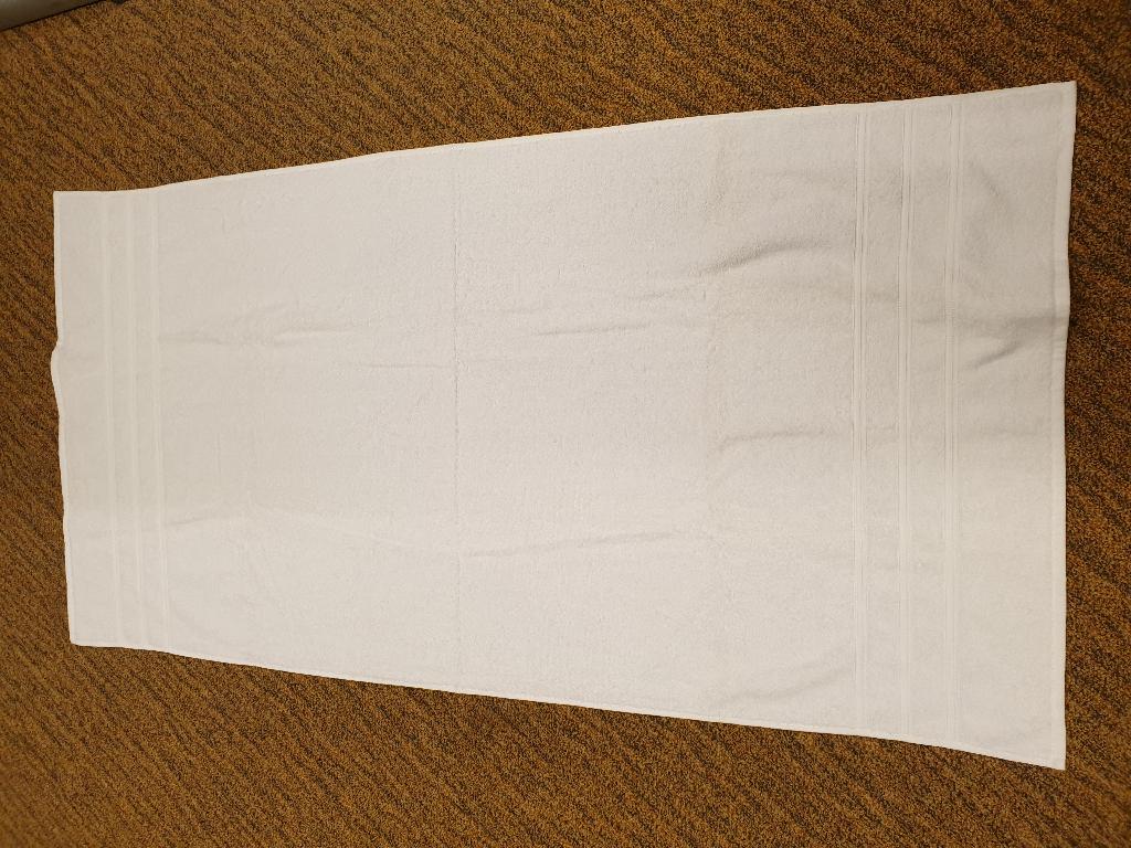 Een handdoek met onder andere de volgende kenmerken:
- bedoeld voor huishoudelijk gebruik;
- vervaardigd van een weefsel van lussenstof van -volgens opgave- katoen;
- rechthoekig van vorm met omgezoomde randen;
- geconfectioneerd;
- aan beide uiteinden voorzien van 3 ingeweven sierstrepen;
- afmetingen van ongeveer 137 x 70 cm.