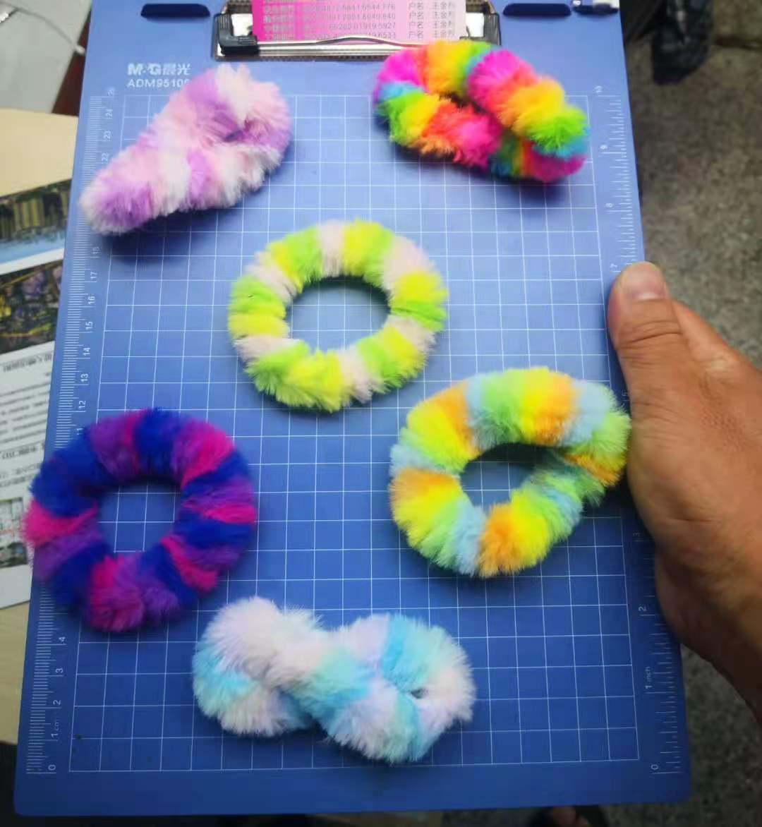 Een zogenoemde haarband met – volgens opgave – onder andere de volgende kenmerken:
- om het haar op te binden;
- een rubberen ring bekleed met textiel;
- een wikkeling van meerkleurig namaakbont;
- het namaakbont is verkregen door opnaaien van textielvezels op een lint van textiel.
Het artikel wordt aangeboden voor de verkoop in het klein in een – niet karakter bepalende – speelgoedcapsule met een diameter van 50 mm, verpakt per 100 stuks in een polybag.