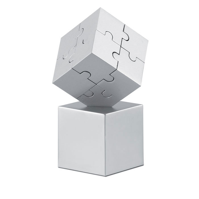 Een tweedelige presse-papier met –volgens opgave- onder andere de volgende kenmerken:
- bestemd om te worden gebruikt als presse-papier;
- vervaardigd van onedel metaal
- bestaat uit 8 magnetische puzzelstukjes in kubusvorm;
- een hol voetstuk in de vorm van een kubus met een driehoekige inkeping;
- afmetingen van het geheel zijn ongeveer 4 x 4 x 8 cm.