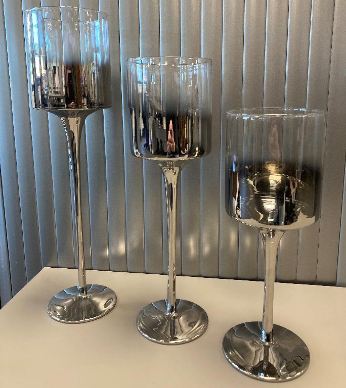 Een zogenoemde set van 3 kandelaars met -volgens opgave- onder andere de volgende kenmerken:
- voor decoratie van bijvoorbeeld woonruimten;
- vervaardigd van glas;
- de ronde voet, de steel en ongeveer de helft van de houder zijn voorzien van een zilverkleurige laag;
- de houder heeft een platte bodem;
- in het midden van de bodem zit een taps teruglopende uitsparing met een diameter van ongeveer 2 cm en diepte van ongeveer 1 cm;
- de uitsparing is niet geschikt om een dinerkaars in te plaatsen;
- er is geen specifieke voorziening voor het plaatsen van een theelichtje;
- een diameter van ongeveer 9 cm;
- een hoogte van ongeveer 25, 30 en 35 cm.
De set wordt aangeboden voor de verkoop in het klein in een kartonnen doos.