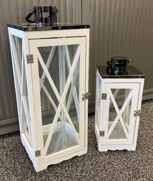 Een lantaarn met -volgens opgave- onder andere de volgende kenmerken en eigenschappen:
- voor verlichtingsdoeleinden met hulp van een kaars;
- een frame van hout;
- ingezette rechthoekige platen van glas waarover een diagonaal van hout loopt;
- een deur met scharnieren en een sluiting van onedel metaal;
- een plat dak van verchroomd onedel metaal voorzien van een rond rookkanaal en een handvat dat tevens dient als ophang-haak;
- rechthoekig;
- een hoogte van ongeveer 34 of 52 centimeter.
De lantaarn wordt per set (2 stuks, in afmetingen verschillend) aangeboden voor de verkoop in het klein.