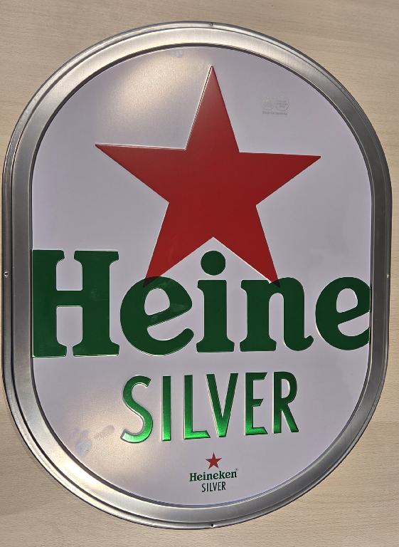 Een zogenoemd muurbord met -volgens opgave- onder andere de volgende kenmerken en eigenschappen:
- bestemd voor reclamedoeleinden;
- vervaardigd van roestvrijstaal;
- een rechthoekige plaat, met afgeronde hoeken;
- die in vorm is gestanst en waarvan de rand gevouwen is;
- voorzien van 4 schroefgaten;
- voorzien van een merknaam en een afbeelding.