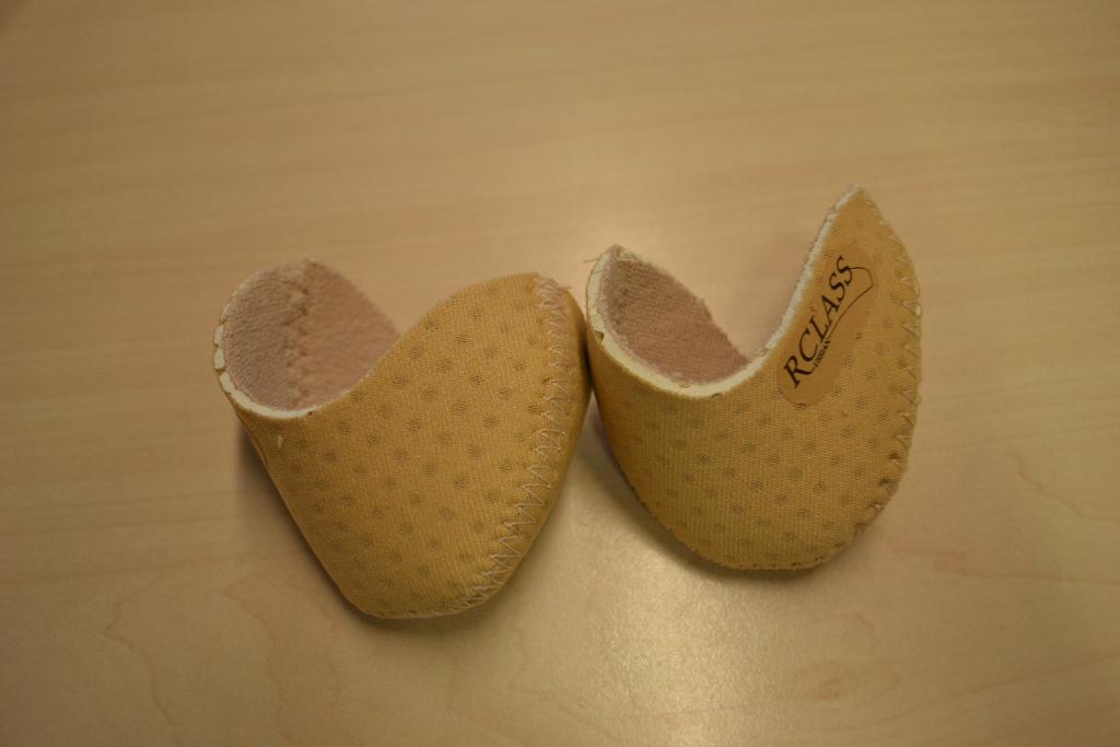 Een teenbeschermer vervaardigd van textiel.
De teenbeschermer is bedoeld voor gebruik in de neus van balletschoenen (spitzen en pointe-schoenen).
De teenbeschermer heeft een binnen- en een buitenzijde van breiwerk. Tussen deze lagen breiwerk bevindt zich een laag zachte kunststof (foam).
De teenbeschermer is aan te merken als een inlegzool en andere losse inlegstukken zoals bedoeld bij GN-onderverdeling 6406 90 50 van de gecombineerde nomenclatuur. De teenbeschermer wordt per paar verpakt en aangeboden in een bedrukt hersluitbaar doorzichtig zakje van kunststof.
