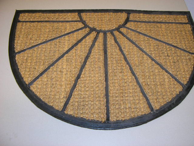 Kokos rubber mat in een halfronde vorm met een afmeting van ongeveer 60 x 40 cm. Deze mat heeft een onderlaag van rubber en een bovenlaag, welke is verdeeld in 10 segmenten, van een kokosweefsel.