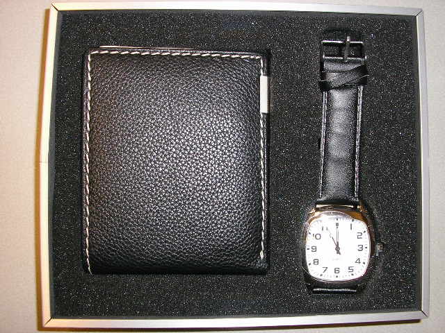 In één verpakking voor verkoop in het klein een horloge en een portemonnee. Het polshorloge is vervaardigd van onedel metaal en heeft een quartz uurwerk met een mechanische aanwijzing van uren, minuten en seconden. De wijzerplaat heeft een enigszins rechthoekige vorm van ongeveer 32x32 mm. Het horloge is voorzien van een lederen polsband. Voor de portemonnee is onder nummer NL-RTD-2005-001090 een BTI afgegeven.