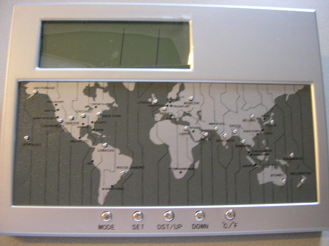 Een digitale bureauklok in een behuizing van kunststof, voorzien van de volgende kenmerken:
- een LCD scherm met de afmetingen 8,5x2,8 cm, voor weergave van 
  tijd, datum en temperatuur;
- een wereldkaart met een aantal hoofdsteden met 22 tiptoetsen, voor 
  het wereldwijd aangeven van de tijd van deze plaatsen;  
- een alarmfunctie;
- een aftellende timerfunctie;
- temperatuurweergave in Celsius of Fahrenheit;
- een inklapbare steun aan de achterzijde;
- vijf bedieningsknoppen;
- een afsluitbare ruimte voor twee AA batterijen;
- met de afmetingen 18 x 13 x 3,7 cm.
De klok met wekkerfunctie geeft aan het geheel zijn wezenlijke karakter. 
Het artikel is opgemaakt voor de verkoop in het klein en wordt tezamen aangeboden met een gebruiksaanwijzing, verpakt in een kartonnen doosje.
