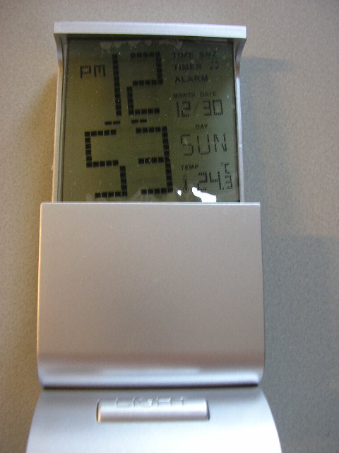 Een digitale bureauklok in een behuizing van kunststof, voorzien van de volgende kenmerken:
- een LCD scherm met de afmetingen 5,7x6,0 cm, voor weergave van 
  tijd, datum en temperatuur;
- een alarmfunctie;
- een aftellende timerfunctie;
- vijf bedieningsknoppen en een lichtknop;
- een muziekfunctie met zeven verschillende melodieën;
- temperatuurweergave in Celsius of Fahrenheit;
- een afsluitbare ruimte aan de achterzijde voor drie AAA batterijen;
- met de afmetingen 13,4x6,5x5,5 cm.
De klok met wekkerfunctie geeft aan het geheel zijn wezenlijke karakter. 
Het artikel is opgemaakt voor de verkoop in het klein en wordt tezamen aangeboden met een gebruiksaanwijzing, verpakt in een kartonnen doosje.