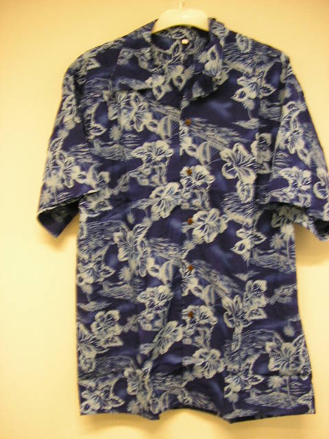 Een kledingstuk om het bovenlichaam te bedekken reikend tot onder het middel, zijnde een overhemd, voor heren of voor jongens, met onder meer de volgende kenmerken: 
- vervaardigd van een weefsel van 100% rayon (kunstmatige vezel); 
- een ronde halsopening voorzien van een kraag; 
- met korte wijde mouwen aan de onderzijde omzoomd; 
- met een gehele opening aan de voorzijde, voorzien van een 
  knoopsluiting (links over rechts); 
- met een omzoomde onderzijde; 
- voorzien van een fleurige print.
Het kledingstuk is verpakt in een polybag.