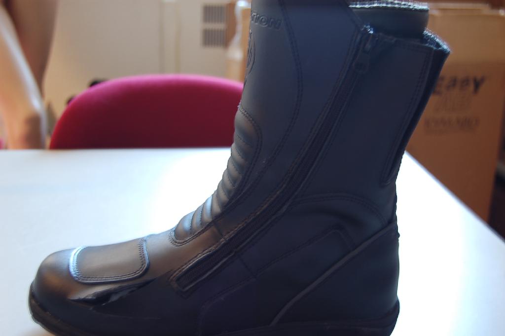 Een laars met een buitenzool van kunststof of rubber en een bovendeel van kunststof voor gebruik op de motorfiets met ondermeer de volgende kenmerken:
- de enkel bedekkend, reikend tot aan de kuit;
- met een beschermende metalen neus;
- met een scheenbeenbeschermer;
- de schacht voorzien van klittenband;
- het bovendeel is ter versiering voorzien van een riempje met een
  gesp van kunststof;
- aan de zijkant, op de omslag staat de merknaam vermeld;
- maatvoering van 36 t/m 46.