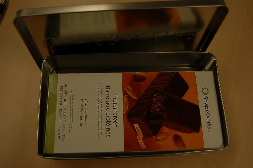 Een chocolade-/proteïnereep, gevuld met een mengsel van verschillende ingrediënten. De reep, met chocolade-pindasmaak, bevat onder andere de volgende ingrediënten: melkeiwitten, glucosesiroop, pindapasta, rijst, magere cacaopoeder en is omhuld met melkchocolade. 
De reep bevat: 
- melkvet geen of minder dan 1,5%; 
- melkproteïnen 18% of meer, maar minder dan 30%; 
- zetmeel/glucose 5% of meer, maar minder dan 25%; 
- sacharose/invertsuiker/isoglucose 5% of meer, maar minder dan 30%. 
De repen, met een nettogewicht van ongeveer 37 gram per stuk, verpakt in aluminiumfolie, zijn opgemaakt voor de verkoop in het klein en per 14 stuks verpakt in een kartonnen doos.
Het geheel is verpakt in een metalen blik waarvoor separaat een BTI is afgegeven onder referentienummer RTD-2007-004251.