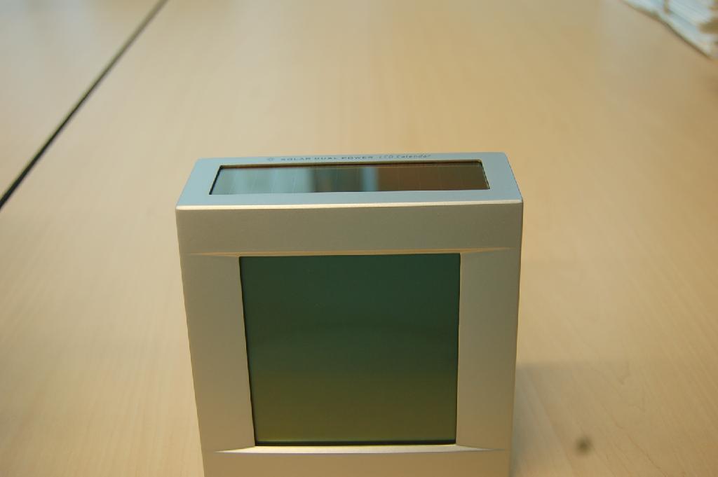"Solar power LCD Calendar", een digitale bureauklok met wekkerfunctie gecombineerd met een thermometer. Het elektrisch werkend artikel, voorzien van een ander uurwerk dan een horloge-uurwerk, heeft onder andere de volgende kenmerken:
- afmetingen (HxBxD) ongeveer 120X121X60 mm;
- afmetingen LCD ongeveer 78x78 mm;
- met datum-, tijd-, kalender- en temperatuur aanduiding;
- met diverse bedieningknopjes aan de achterzijde;
- aan de onderzijde voorzien van een compartiment voor twee batterijen; 
Het wezenlijk karakter van het artikel wordt bepaald door de bureauklok met wekkerfunctie.