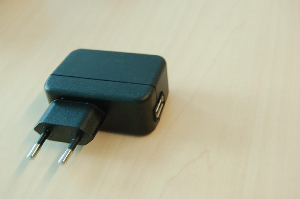 Een zogenaamde USB Omzetter zijnde een oplader in een behuizing van voorgevormde kunststof met ondermeer de volgende kenmerken:
- voorzien van een AC stekker 220-230 Volt;
- voorzien van een USB aansluiting;
- kan diverse apparaten opladen die zijn voorzien van een USB ingang;
Het apparaat is niet alleen van de soort gebruikt voor telecommunicatietoestellen en/of automatisch gegevens verwerkende machines.