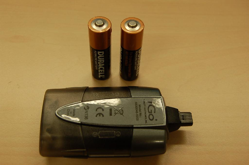 Een samengesteld artikel bestaande uit twee niet-oplaadbare cilindervormige AA alkaline batterijen en een kunststof behuizing voorzien van metalen elementen voor het geleiden van elektrische stroom. Het apparaat is bedoeld om bijvoorbeeld een mobiele telefoon, oortelefoon enz. van elektriciteit te voorzien. Het artikel is verpakt, opgemaakt voor de verkoop in het klein, tezamen met een gebruiksaanwijzing. De kenmerkende hoofdfunctie van het geheel is de stroomvoorziening door middel van de batterijen.