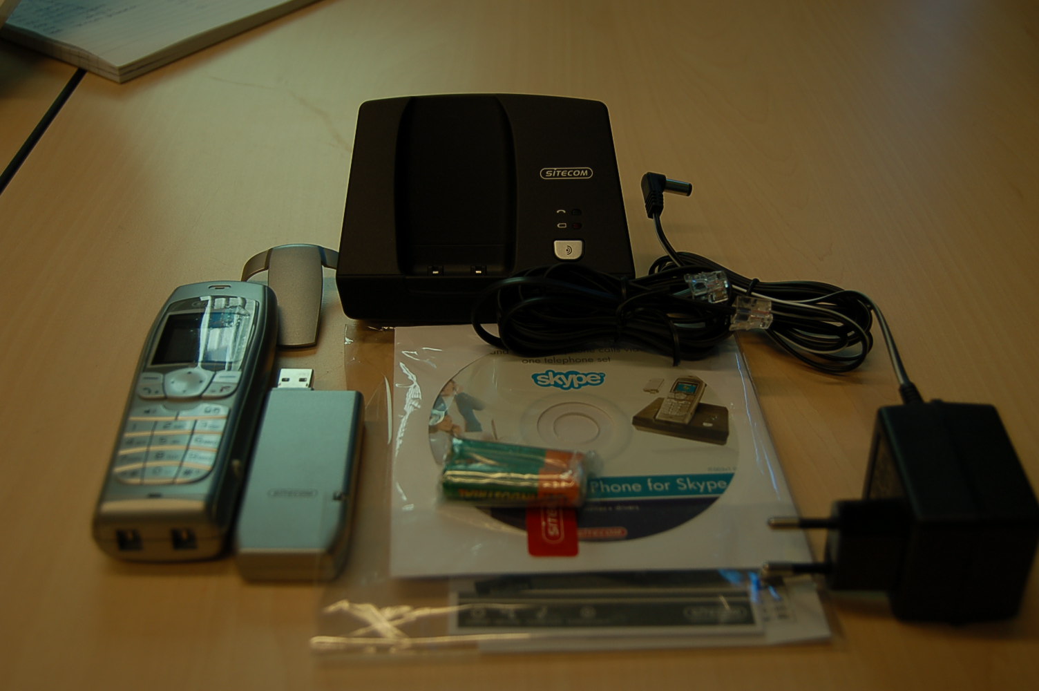 Een gecombineerd apparaat bestaande uit een analoge dect telefoon en een zogenaamde internet (skype) telefoon met ondermeer de volgende samenstelling en kenmerken:
- basisstation voorzien van 7.5 V AC en RJ 11 aansluiting;
- draadloos telefoontoestel voorzien van een LCD scherm en diverse 
  bedieningstoetsen;
- een usb zender en ontvanger.
Door het apparaat met een automatische gegevensverwerkende machine en op een normale analoge telefoonlijn te verbinden is het mogelijk om met één toestel zowel Skype internet telefoongesprekken als analoge telefoongesprekken te voeren.
Het apparaat wordt aangeboden voor de verkoop in het klein, verpakt in een kartonnen doos tezamen met een statische omvormer, twee AAA batterijen , een RJ 11 kabel, installatie CD-Rom en een gebruikershandleiding.
Noch de internet telefoon noch de analoge telefoon zijn bepalend voor het wezenlijk karakter.