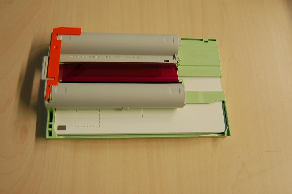 "Ink and Paper Integrated Cartridge", een assortiment bestaande uit:
- een kunststof cassette bevattende onder andere 2 spoelen (in cilindervormige behuizingen) met inktlint van kunststof, bestaande uit segmenten met verschillende kleuren, waarbij de kleurstoffen door verhitting op een drager worden overgebracht (zogenaamde kleurstofsublimering);
- 50 velletjes papier ("postcard size").
Het inktlint is opgebouwd uit de drie basiskleuren geel, magenta en cyaan. Het geheel, met de afmetingen van ongeveer 18x11 cm, is vervaardigd voor het afdrukken van foto's  met  behulp van een bepaald model fotoprinter. Het assortiment, opgemaakt voor de verkoop in het klein en verpakt in een kartonnen doos, ontleent zijn wezenlijk karakter aan het kunststof inktlint.