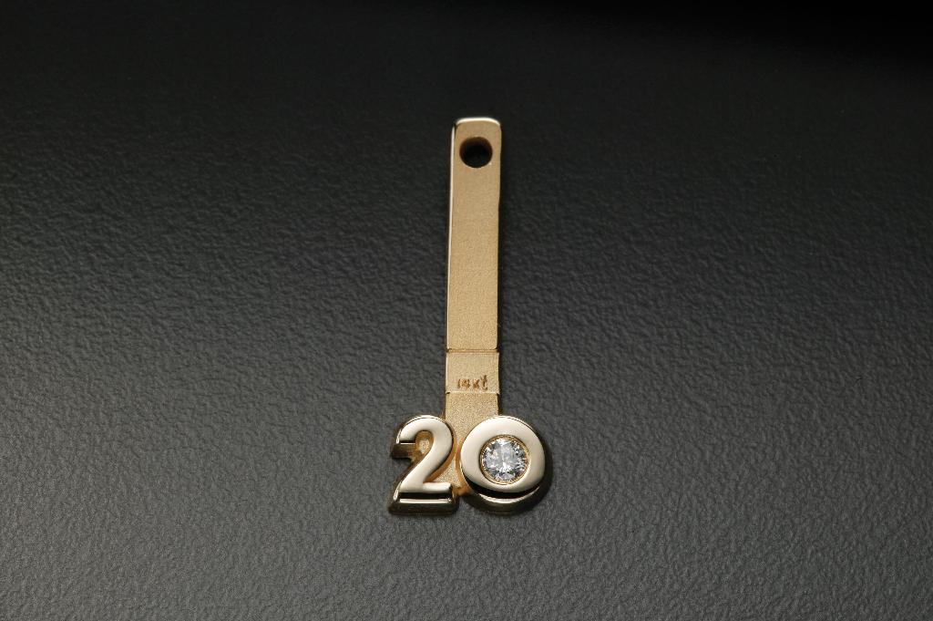 Een 14 karaats gouden hanger (strip) voorzien van een ronde opening aan de bovenzijde en een getal aan de onderzijde. In het getal is een diamant van 1-10-pt S13 geplaatst.
