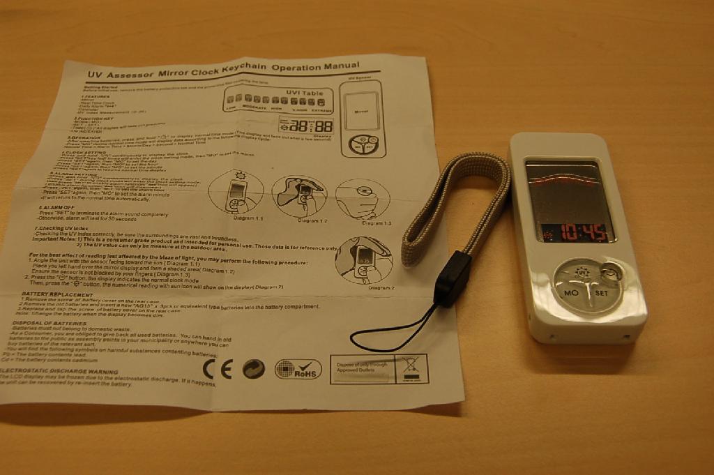 "UV Assessor Mirror Clock Keychain", een gecombineerd apparaat bestaande uit:
- een elektrisch werkend klokje met horloge-uurwerk, voorzien van alarm- en kalenderfunctie;
- een UV index meter.
Het geheel is gevat in een kunststof behuizing met de afmetingen (LxBxD) van ongeveer 8,3x3,5x1,4 cm, dat onder andere is voorzien van een LCD display, een spiegeltje en bedieningsknopjes. Aan de achterzijde bevindt zich een uitsparing met klepsluiting voor de batterijen. Het apparaat, waarbij het wezenlijke karakter wordt bepaald door het digitale klokje, wordt aangeboden tezamen met een meertalige gebruiksaanwijzing, drie knoopcelbatterijen en een koordje.