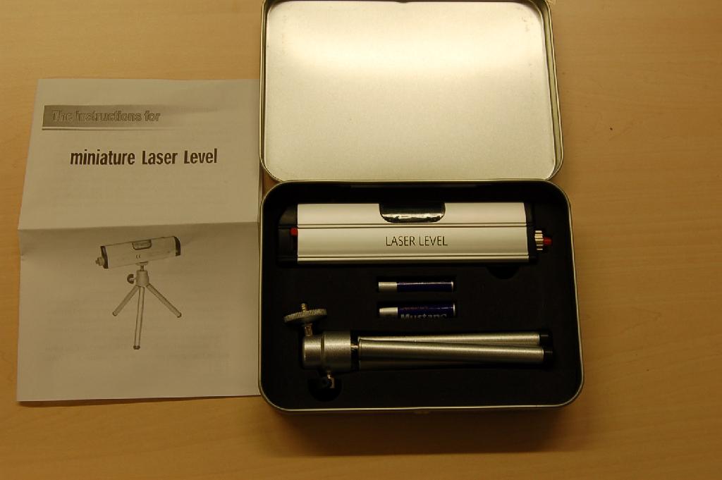"Miniature laser level", een waterpas met laserstraal. De waterpas bestaat uit een behuizing van onedel metaal waarin een libel, de laserdiode, een ruimte voor twee batterijen en diverse bedieningsknopjes zijn gevat. De waterpas wordt aangeboden in een blikje van onedel metaal tezamen met een statiefje en twee AAA batterijen. De waterpas bevat geen artikelen van post 8540, 8541 of 8542 zoals bedoeld bij de Aanvullende aantekening 1 (GN) op hoofdstuk 90.
