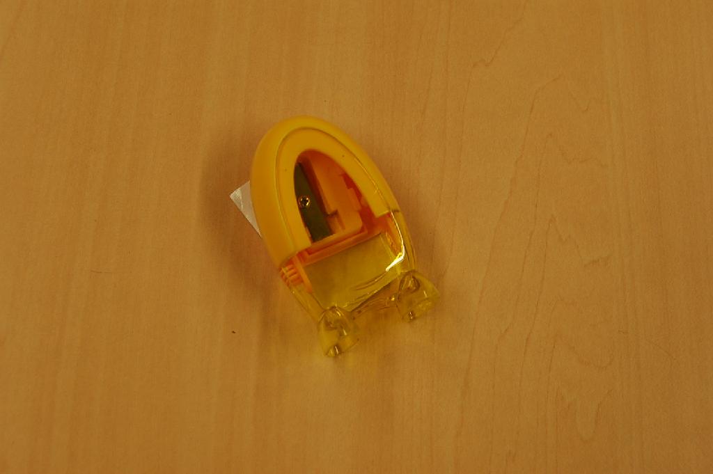 Een kleine potloodslijper met de volgende kenmerken:
- met een mesje van onedel metaal;
- in een kunststof behuizing;
- met een afneembaar doorzichtig kunststof reservoir;
- met een hoogte van ongeveer 65 mm.