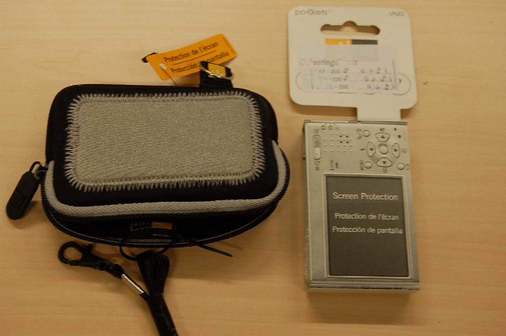 Een tasje zijnde een bergingsmiddel met een buitenzijde van synthetische textielstof (neopreen) met ondermeer de volgende kenmerken:
- met kunststof ritssluiting;
- met koordje voorzien van musketonhaak;
- voorzien van een metalen D-vormige ring;
- afmetingen van ongeveer 11x7,5x3 cm;
- gewicht van ongeveer 80 gram.