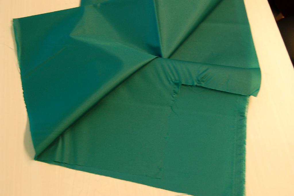 Een geverfd weefsel, bevattende meer dan 85 gewichtsprocenten synthetische filamenten van polyamiden. Er is met het blote oog geen deklaag zichtbaar. Het weefsel wordt aangeboden op rollen met een breedte van ongeveer 150 cm.