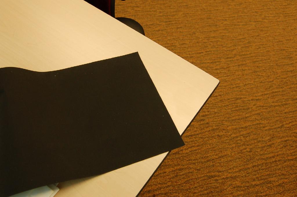 Rood en zwart geverfd weefsel met aan beide zijden een deklaag van rubber. De deklaag is met het blote oog zichtbaar. Het gewicht bedraagt resp. ca. 624 g/m2 en ca. 644 g/m2. Het product wordt – volgens opgave - toegepast voor maritieme doeleinden en aangeboden op rollen met een breedte van ongeveer 150 cm.