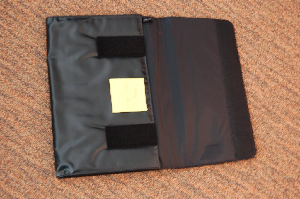 Een envelop tas voor een laptop met een buitenzijde van kunststof in vellen met ondermeer de volgende kenmerken:
- met een beschermende overslag voorzien van een klittenbandsluiting;
- aan de zijkanten is het kunststof vervangen door een elastische band;
- op de beschermende overslag is een kunststof etiket gestikt voorzien van een merknaam;
- de tas heeft afmetingen van ongeveer 360 x 265 x 20 mm.