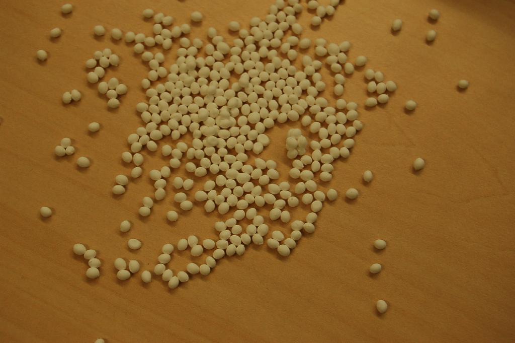 Bereide niet-gevulkaniseerde rubber bestaande uit een copolymeer van isopreen en styreen, voorzien van diverse toevoegingen waaronder pigmenten, in de vorm van witte korrels.