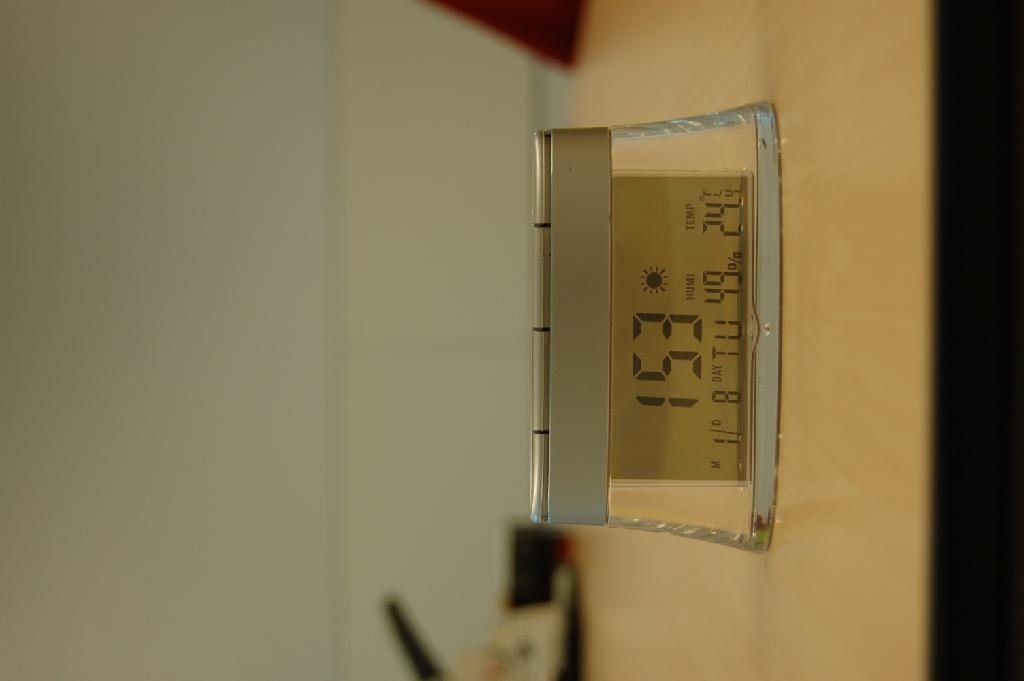 Een digitaal bureauklokje voorzien van een ander uurwerk dan een horloge-uurwerk, heeft onder andere de volgende kenmerken: 
- afmetingen (HxBxD) ongeveer 105X30X55 mm; 
- afmetingen LCD ongeveer 70x30 mm; 
- met datum-, tijd-, kalender- en temperatuur aanduiding; 
- met diverse bedieningknopjes aan de bovenzijde; 
- aan de bovenzijde van de achterkant voorzien van een compartiment voor 1 celbatterij.
Het klokje kan functioneren op 1 celbatterij of op zon energie waarvoor 4 zonnecellen aan de bovenzijde zijn aangebracht. Het wezenlijk karakter van het artikel wordt bepaald door de bureauklok met wekkerfunctie. Het klokje wordt aangeboden in een kartonnen verpakking met bijpakking van een instructiefolder en is gereed voor de verkoop in het klein.