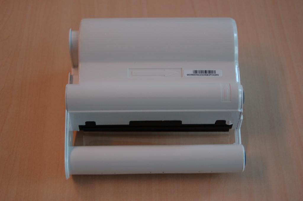 Een kunststof cassette bevattende onder andere 2 spoelen (in cilindervormige behuizingen) met inktlint van kunststof, bestaande uit segmenten met verschillende kleuren, waarbij de kleurstoffen door verhitting op een drager worden overgebracht (zogenaamde kleurstofsublimering). Het inktlint is opgebouwd uit de drie basiskleuren geel, magenta en cyaan. De cassette is bedoeld om geplaatst te worden in een fotoprinter die aangesloten wordt op een zogenaamde "digitale fotolijst".
