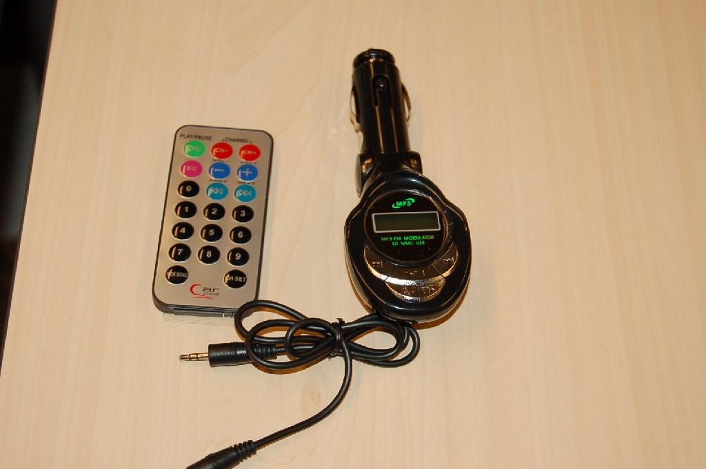 Een gecombineerd apparaat bestemd voor het gebruik in een motorvoertuig, voorzien van ondermeer de volgende uiterlijke en technische kenmerken:
- een draadloos zendtoestel voor radio-omroep (FM), zijnde een 
  zogenoemde "FM Transmitter" die ondermeer MP3 bestanden afkomstig 
  van een MP3 speler, SD geheugenkaart of geheugenstick afspeelt 
  over de autoradio;
- een behuizing van kunststof met verschillende bedieningsknoppen, 
  een passief LCD afleesscherm, een SD geheugenkaartlezer, een USB 
  connector en een 3.5 mm audio connector;
- met 206 voorgeprogrammeerde FM zenders;
- aan de behuizing zit een beweegbare sigarettenaansteker 
  aansluiting vast om het toestel van stroom te voorzien.
Het apparaat moet binnen het toegestane bereik op dezelfde FM frequentie als die van de autoradio worden ingesteld, zodat de af te spelen muziek door het gebruik van de autoradio over de boxen van de auto kan worden afgespeeld. De kenmerkende hoofdfunctie wordt bepaald door het zendtoestel voor radio-omroep. Het apparaat wordt tezamen geleverd met de benodigde kabel, afstandsbediening en gebruiksaanwijzing.