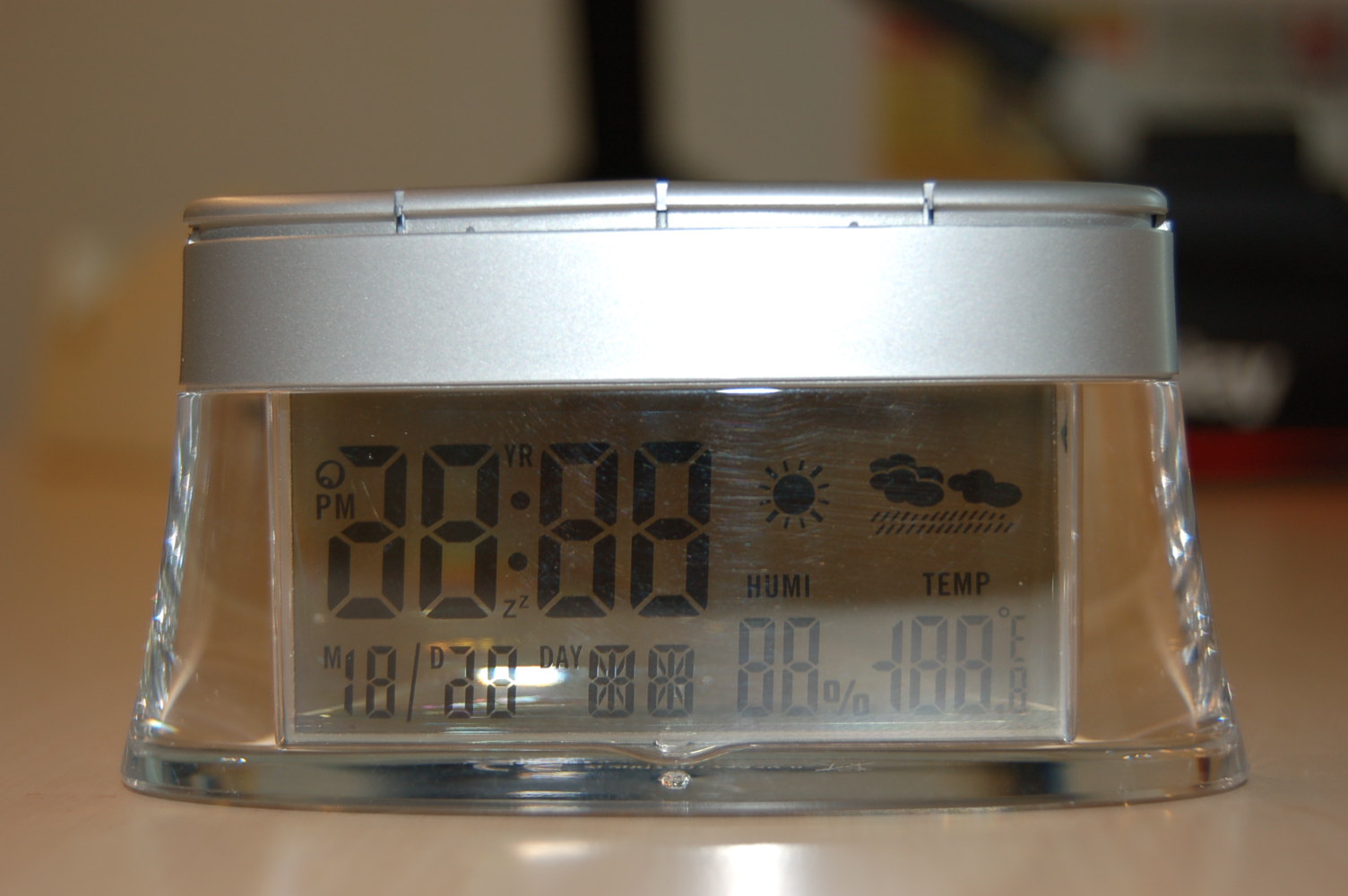 Een digitaal bureauklokje voorzien van een ander uurwerk dan een horloge-uurwerk, heeft onder andere de volgende kenmerken: 
- afmetingen (HxBxD) ongeveer 105X30X55 mm; 
- afmetingen LCD ongeveer 70x30 mm; 
- met datum-, tijd-, kalender-, temperatuur aanduiding en weersymbool; 
- met bedieningknopjes aan de bovenzijde; 
- aan de bovenzijde van de achterkant voorzien van een compartiment voor 1 celbatterij.
Het klokje kan functioneren op 1 knoopcelbatterij of op zonne-energie, waarvoor 4 zonnecellen aan de bovenzijde zijn aangebracht. Het wezenlijk karakter van het artikel wordt bepaald door de bureauklok met wekkerfunctie. Het klokje wordt aangeboden in een kartonnen verpakking tezamen met een instructiefolder en is gereed voor de verkoop in het klein.