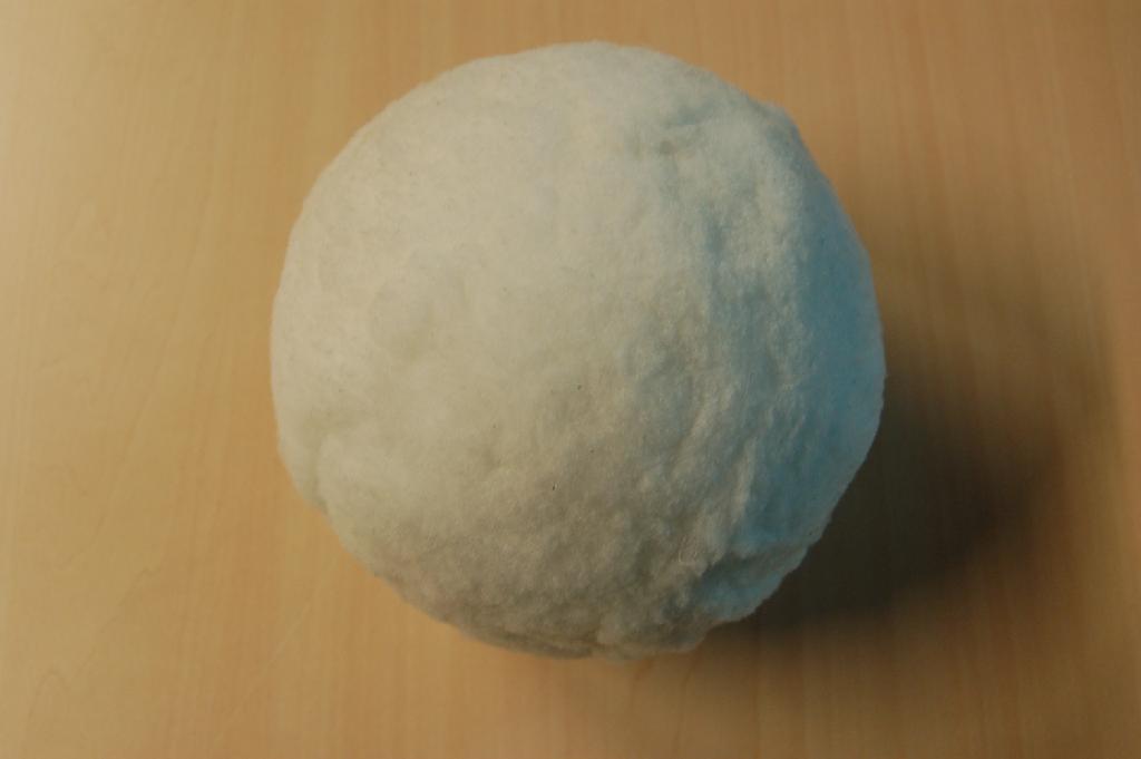 Een sneeuwbal, zijnde een samengesteld werk, met ondermeer de volgende kenmerken:
- een kern van polystyreen, met een diameter van ongeveer 120 mm.;
- aan de buitenzijde volledig voorzien van een opgelijmde laag wattenvlies, van synthetische vezels, met een    dikte van ongeveer 15 mm.
Het decoratieve artikel heeft geen bijzondere kenmerken die wijzen op het gebruik als kerstfeestartikel. Het wezenlijk karakter wordt bepaald door het wattenvlies van synthetische vezels.