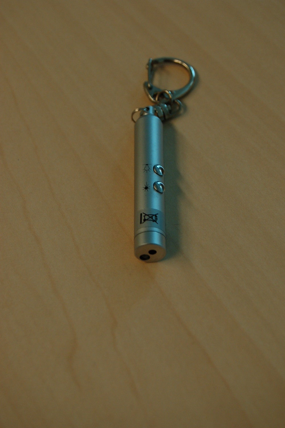 Een zogenoemde "laserpointer" gecombineerd met een zaklamp in een cilindrische behuizing van onedel metaal, voorzien van ondermeer de volgende uiterlijke en technische kenmerken:
- een laser aanwijspen werkend met een roodgekleurd licht;
- een zaklamp werkend met een blauwe LED als lichtbron;
- twee bedieningsknoppen;
- werkend op drie knoopcel batterijen;
- het batterijvak wordt afgesloten met een schroefdop waaraan een 
  splitring met kettinkje en sleutelring van onedel metaal is 
  bevestigd om te worden gebruikt als sleutelhanger;
- afmetingen van ongeveer 60 x 9 mm.
Gelet op het gebruik en de kracht van de functies van de zaklamp of de aanwijspen dient het wezenlijke karakter te worden toegekend aan één van deze functies, echter noch de zaklamp noch de aanwijspen zijn kenmerkend voor het geheel. Het apparaat wordt tezamen aangeboden met drie knoopcel batterijen.