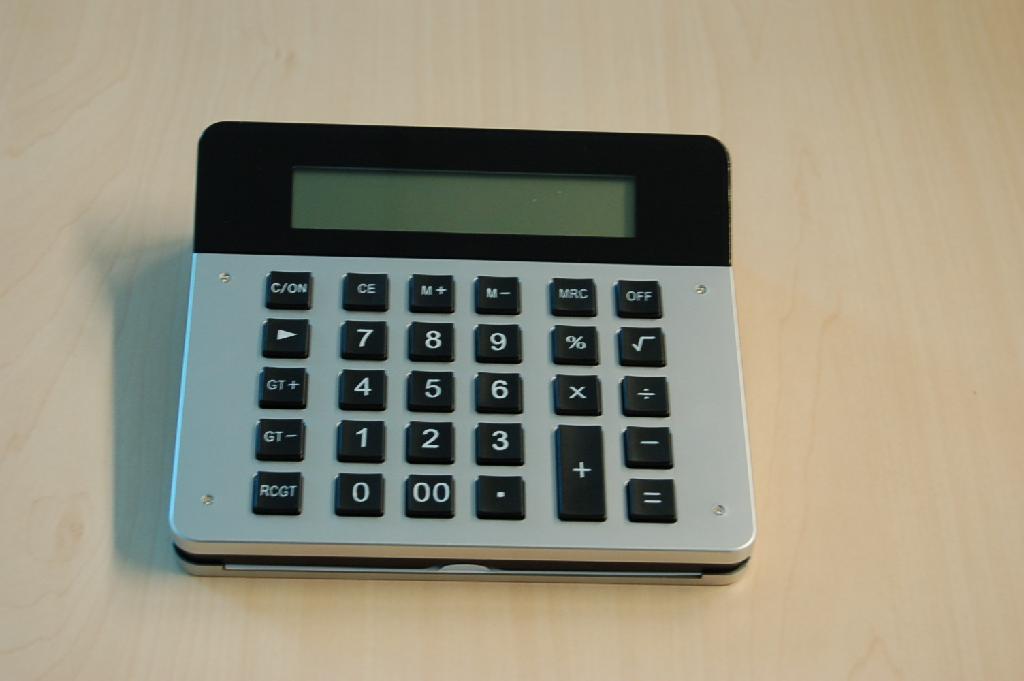 Een samengesteld artikel bestaande uit een rekenmachine en fotolijst met ondermeer de volgende kenmerken:
- 12 digits rekenmachine;
- LCD display klok met alarm, dag en datum aanduiding;
- 12/24 uur aanduiding;
- temperatuur display in Celsius of Fahrenheit;
- reminder voor verjaardagen;
- timer; 
- fotolijst afmeting 89x127 mm;
- geleverd met 2 AAA batterijen.
Het wezenlijk karakter van het geheel wordt bepaald door de rekenmachine.
Het geheel is opgemaakt voor de verkoop in het klein en is tezamen verpakt met 2 AAA batterijen en een gebruiksaanwijzing in een kartonnen doos.