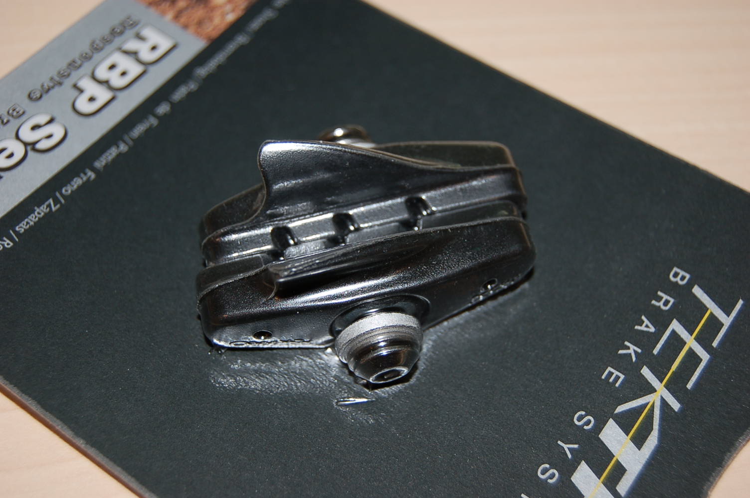 Een remschoen voor een niet gemotoriseerd rijwiel, bestaande uit een metalen houder (cartridge) met een - volgens opgave- rubberen remblok en een schroef met sluitringen voor het bevestigen. De remschoen is te onderkennen als een deel van een rem voor een fiets van GN 8712.