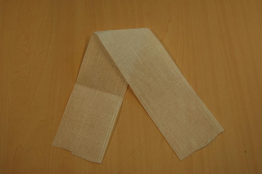 Een weefsel bestaande uit:
- een bovenlaag van synthetische filamenten (parallelliggende 
  draden);
- een tussenlaag van synthetische filamenten (parallelliggende 
  draden);
- een onderlaag van gebonden textielvlies.
Het geheel is aan elkaar gelijmd waarbij de kruispunten van de draden van de boven- en tussenlaag aan elkaar zijn gehecht zoals bedoeld bij aantekening 9 op afdeling XI van de gecombineerde nomenclatuur.   
Het weefsel wordt toegepast voor raamdecoratie en aangeboden op rollen met een lengte van ongeveer 1800 meter en een breedte van ongeveer 63,5 of 127 mm.