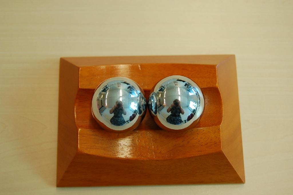 Een zogenoemde Chinese anti-stress set bestaande uit twee gekalibreerde, gepolijste, stalen kogels en een houten standaard met ondermeer de volgende kenmerken:
- de kogels hebben een diameter van ongeveer 35 mm. en zijn voorzien van een mechanisme die bij beweging van    de kogels een melodie voortbrengen;
- de standaard heeft afmetingen van ongeveer (LxBxH) 140 x 100 x 38 mm. en is aan de bovenzijde voorzien van    een geulvormige uitsparing waar de kogels op uitgestald kunnen worden.
Het wezenlijke karakter van het geheel wordt bepaald door de twee kogels.