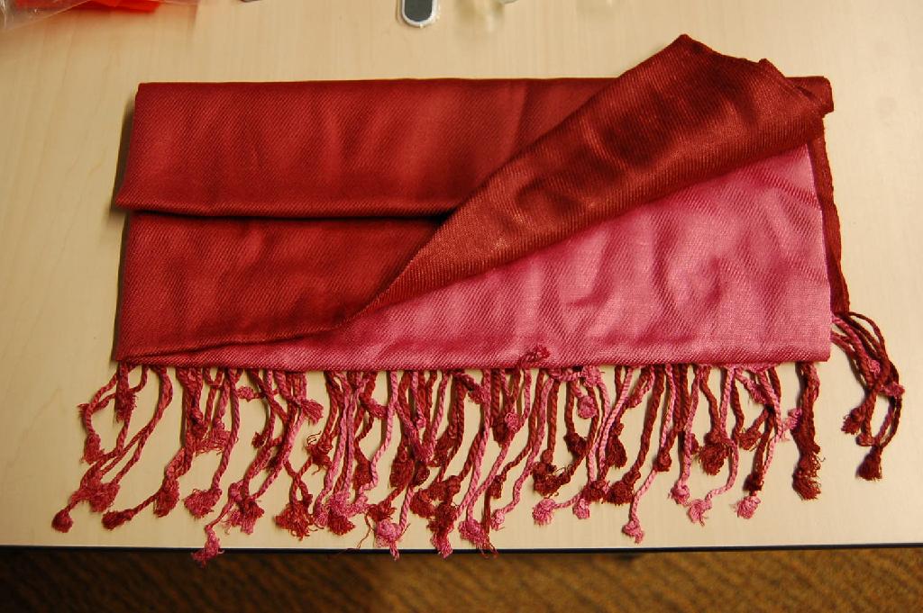Een geconfectioneerd artikel, zijnde een sjaal, met onder andere de volgende kenmerken:
- vervaardigd van weefsel van -volgens opgave- 100 % viscose;
- aan beide korte zijden voorzien van franje;
- dubbel geweven aan de lange zijden;
- een geleidelijk kleurverloop van licht naar donker;
- een afmeting van ongeveer 70 x 180 cm.