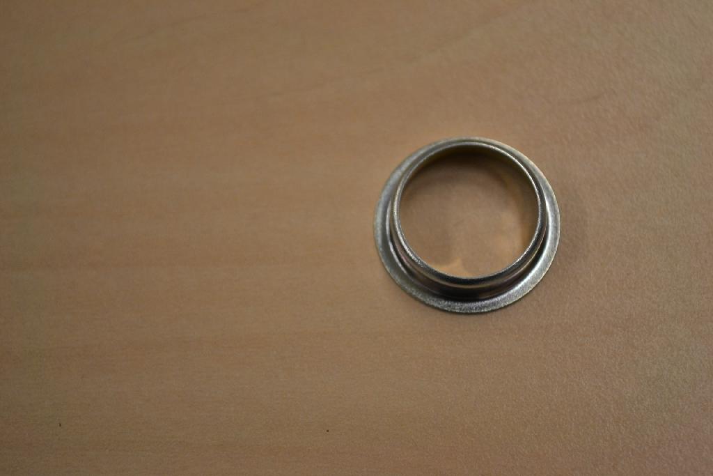 Een ring met -volgens opgave- onder meer de volgende kenmerken:
- bestemd als afsluitring in een airco;
- vervaardigd van ijzer of staal, geplateerd met zink met een dikte van 5 tot 10 µm;
- een buitenste diameter van ongeveer 2,1 cm, een inwendige 
  diameter van ongeveer 1,5 cm en een opstaande rand van ongeveer 
  0,5 cm aan de binnenzijde.