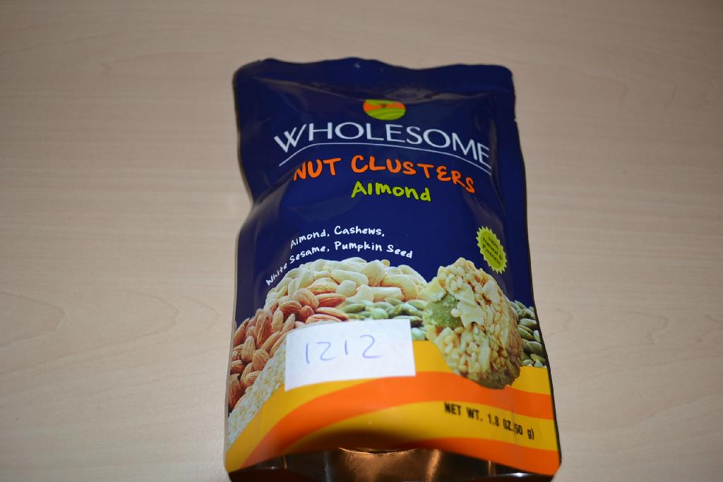 Een mengsel van noten en zaden, in de vorm van een rond schijfje, -volgens opgave- onder andere de volgende ingrediënten bevattend:
- gesneden amandel;
- cashewnoten;
- wit sesamzaad;
- suiker;
- pompoenzaad;
- glucosesyroop;
- rijstolie;
- natuurlijke aroma;
- zeezout;
- soja lectine;
- natuurlijke vitamine E;
- citroenzuur;
Het betreft een mengsel van andere noten en zaden met een gehalte aan tropische noten van minder dan 50 gewichtspercenten, op andere wijze bereid of verduurzaamd, in een verpakking van niet meer dan 1 kg, gebrand. Indeling onder hoofdstuk 8 kan niet plaatsvinden, omdat er bewerkingen zijn uitgevoerd die verder gaan dan toegestaan onder dit hoofdstuk.