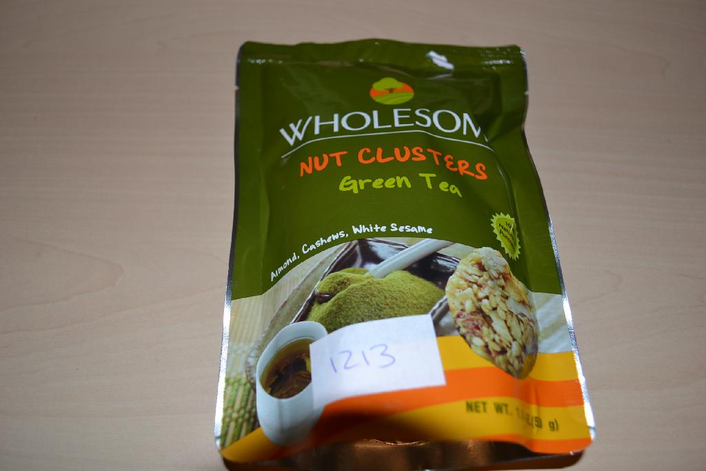 Een mengsel van noten en zaden, in de vorm van een rond schijfje, -volgens opgave- onder andere de volgende ingrediënten bevattend:
- gesneden amandel en stukjes amandel;
- cashewnoten;
- wit sesamzaad;
- suiker;
- glucosesyroop;
- rijstolie;
- groene thee poeder;
- natuurlijke aroma;
- zeezout;
- soja lectine;
- natuurlijke vitamine E;
- citroenzuur;
Het betreft een mengsel van andere noten en zaden met een gehalte aan tropische noten van minder dan 50 gewichtspercenten, op andere wijze bereid of verduurzaamd, in een verpakking van niet meer dan 1 kg, gebrand. Indeling onder hoofdstuk 8 kan niet plaatsvinden, omdat er bewerkingen zijn uitgevoerd die verder gaan dan toegestaan onder dit hoofdstuk.