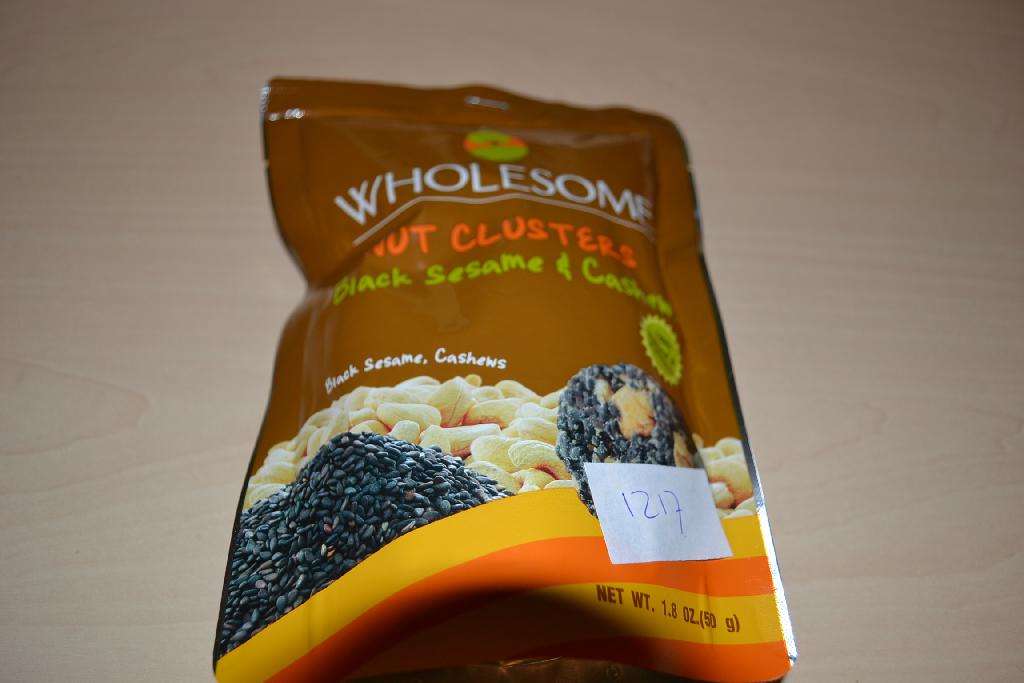 Een mengsel van noten en zaden, in de vorm van een rond schijfje, -volgens opgave- onder andere de volgende ingrediënten bevattend:
- cashewnoten;
- zwart sesamzaad;
- suiker;
- glucosesyroop;
- rijstolie;
- natuurlijke aroma;
- zeezout;
- soja lectine;
- natuurlijke vitamine E;
- citroenzuur;
Het betreft een mengsel van andere noten en zaden met een gehalte aan tropische noten van minder dan 50 gewichtspercenten, op andere wijze bereid of verduurzaamd, in een verpakking van niet meer dan 1 kg, gebrand. Indeling onder hoofdstuk 8 kan niet plaatsvinden, omdat er bewerkingen zijn uitgevoerd die verder gaan dan toegestaan onder dit hoofdstuk.