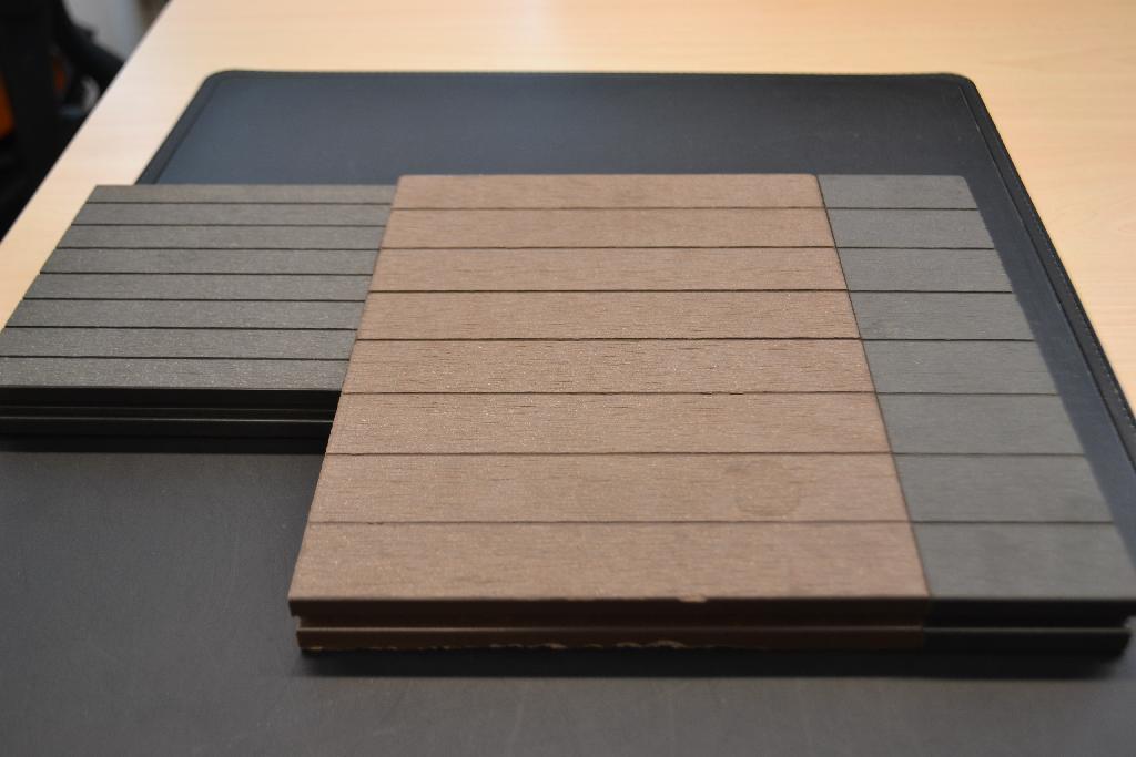 Dekplanken, zijnde terrasdelen met onder andere de volgende kenmerken en bestaande uit de volgende bestanddelen:
- houtvezels;
- polyethyleen;
- stabilisatoren en dergelijke;
- aan de bovenzijde korrelig en getextureerd;
- aan de onderzijde voorzien van ribbels;
- aan beide zijkanten voorzien van een groef over de gehele lengte;
- met een breedte van 14,5 of 25 cm;
- in diverse lengten verkrijgbaar;
- voor gebruik in de tuin en dergelijke.
Omdat het product zijn samenhang ontleent aan de kunststof is de kunststof bepalend voor het wezenlijke karakter. De houtvezels dienen alleen als vulstof en zijn derhalve niet karakterbepalend 
voor het product.