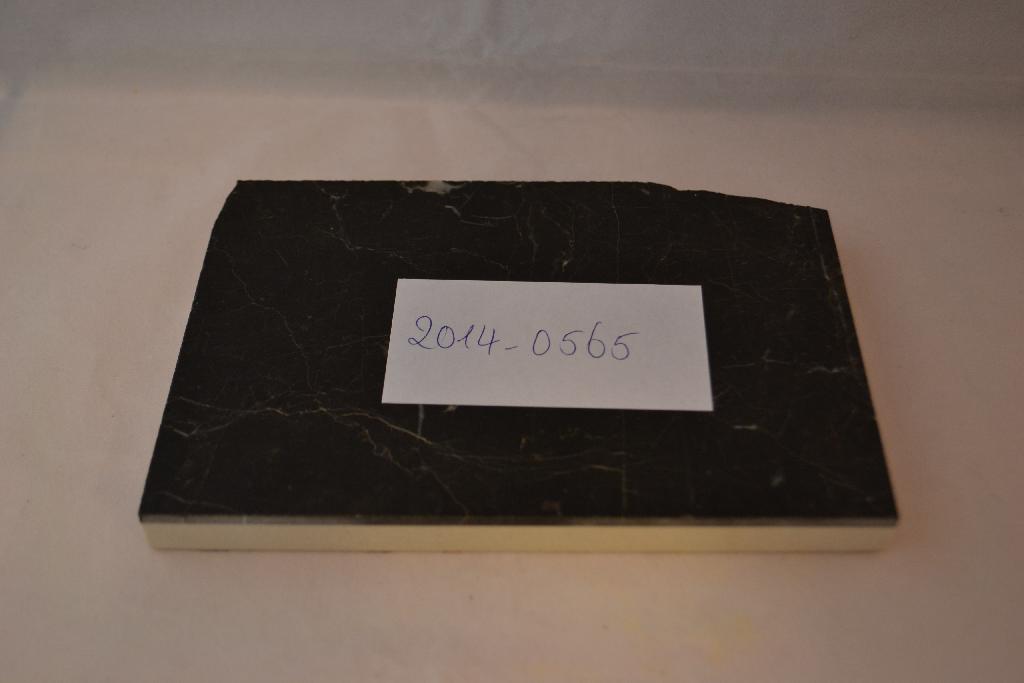 Een zogenoemde laminato vloertegel, met -volgens opgave- onder andere de volgende kenmerken:
- een bovenlaag van andere kalksteen;
- gezoet afgewerkt;
- met een dikte van 3 mm;
- een onderlaag van keramiek;
- aan de onderzijde voorzien van een ruitpatroon;
- met een dikte van 9 mm;
- recht afgewerkte zijkanten zonder facet;
- een totale materiaaldikte van 1,2 cm;
- in diverse afmetingen;
- voor gebruik binnenshuis.
De bovenlaag van kalksteen is onbeweeglijk verlijmd op de onderlaag van keramiek. Het wezenlijke karakter van het samengestelde artikel wordt toegekend aan de bovenlaag van andere kalksteen zoals bedoeld bij GN-onderverdeling 6802 92 00 van de gecombineerde nomenclatuur.