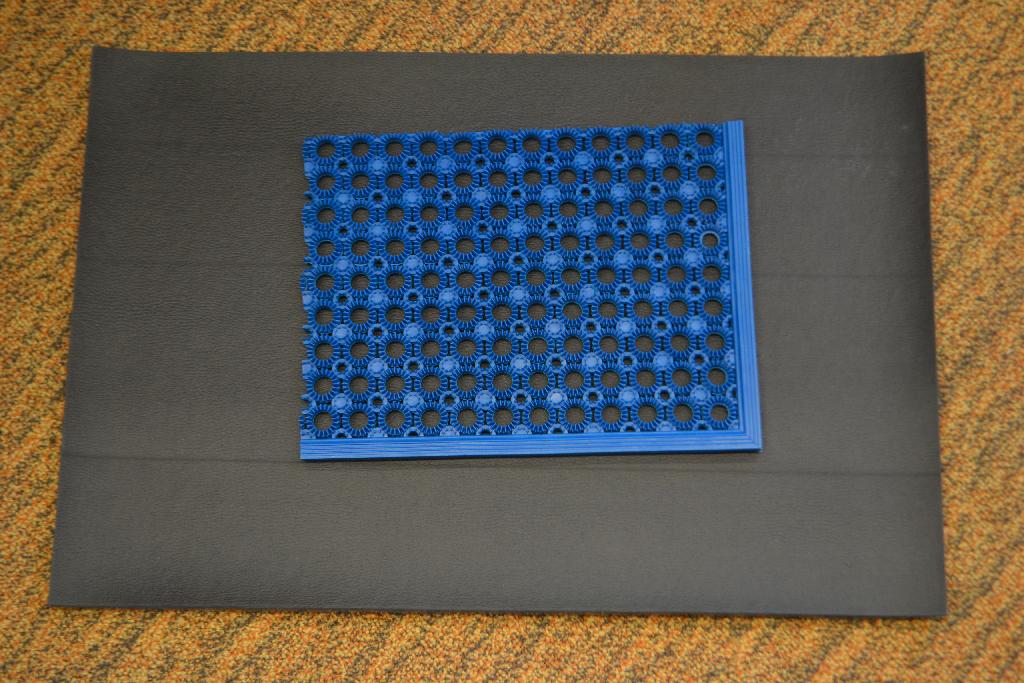 Een deurmat met -volgens opgave- onder andere de volgende kenmerken:
- in zijn geheel vervaardigd van polyvinylchloride;
- rechthoekig van vorm;
- een ronde gaten motief; 
- afmetingen van ongeveer 48 x 62 x 1,1 cm;
- verkrijgbaar in verschillende kleuren.
De matten zijn per 12 stuks verpakt in een doos.
