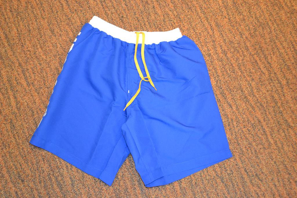Een korte broek met onder meer de volgende kenmerken:
- vervaardigd van 100% polyester;
- in de taille voorzien van 3 tunnels, de bovenste en onderste met elastiek en in het midden een aantrekkoord;
- broekspijpen tot halverwege het bovenbeen;
- een binnenbroek van mesh (grofmazig breiwerk);
- niet voorzien van een opening aan de voorzijde;
- aan 1 zijkant voorzien van een merknaam.