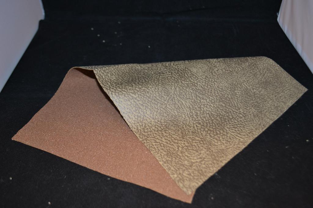 Een weefsel van synthetische stapelvezels met onder andere de volgende kenmerken en eigenschappen:
- bestaande uit 3 lagen;
- een laag weefsel met een inslag van niet-getextureerde filamenten en een ketting van niet getextureerde 
  filamenten en stapelvezels;
- een laag breiwerk van polyester;
- een kleeflaag;
- op rollen;
- bestemd voor meubelstoffering.
Het doek wordt geleverd op rollen met een breedte van 140 cm met een marge van 2 cm en een lengte van ongeveer 40 meter en is –volgens opgave– bedoeld voor het bekleden van meubelen. Het betreft een ander weefsel van synthetische stapelvezels, zoals bedoeld bij GN-onderverdeling 5515 19 90 van de gecombineerde nomenclatuur.
