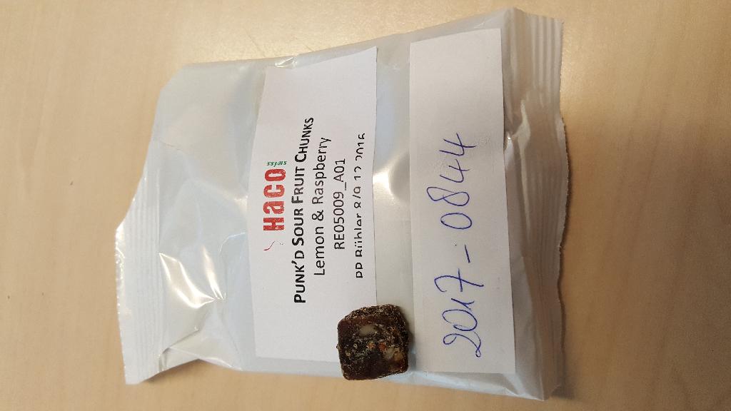 Bruine blokjes met hier en daar beige stukjes met onder meer de volgende kenmerken en eigenschappen:
- afmetingen van ongeveer 1 x 1 cm;
- bedoeld voor menselijke consumptie;
- dadels;
- gedroogde pruimen;
- zonnebloempitten;
- gedroogde frambozen;
- citroenschilpoeder;
- rijstmeel;
- citroenolie.
